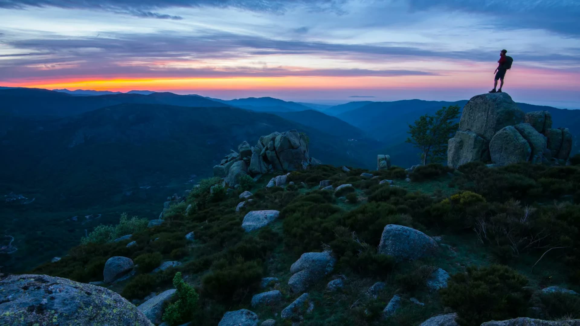 Un randonneur au sommet des monts d'Ardèche au coucher du soleil