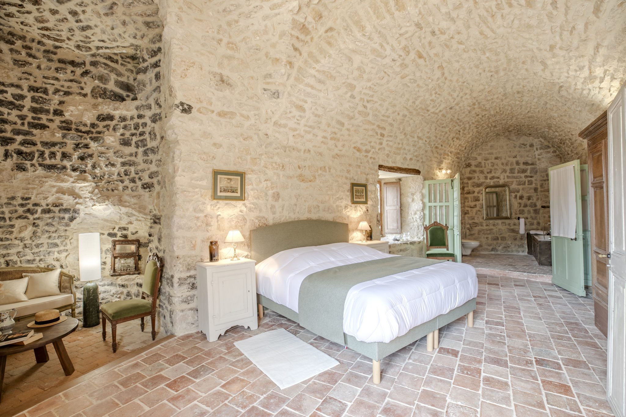 Chambre voûtée du donjon, murs de pierre et lit face à la fenêtre